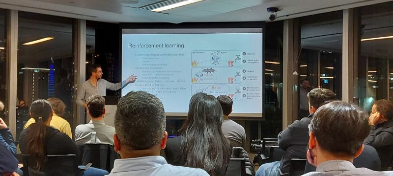 Mike speaking enthusiastically to a crowd about reinforcement learning